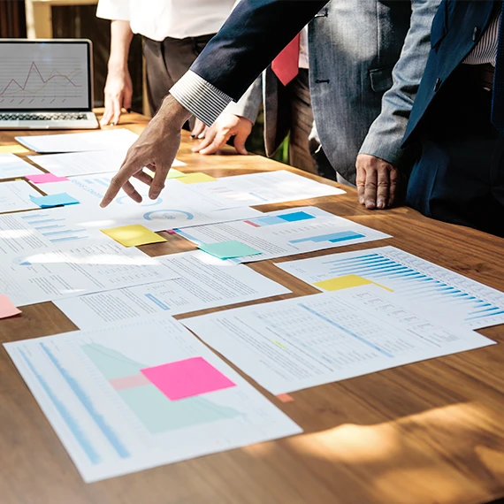 ymbolbild: Dokumente und Laptop mit Analyse-Graph auf einem Schreibtisch – Messbarer Mehrwert durch transparente Dokumentenprozesse